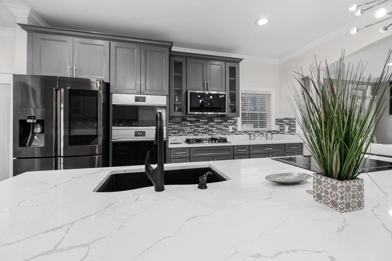 About Sleek modern kitchen featuring marble countertops and elegant cabinetry.