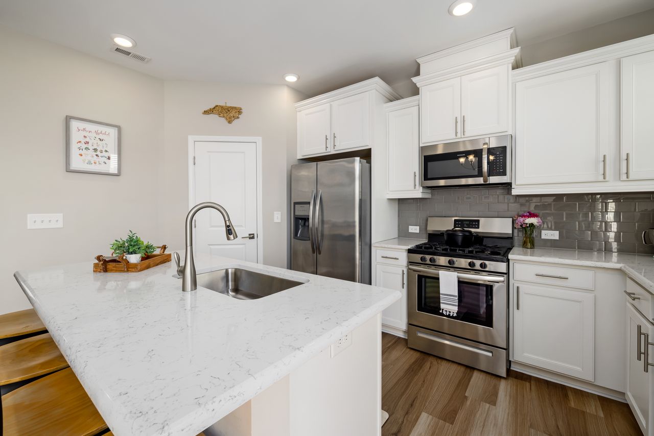 Mastering the First Impression: Your intriguing post title goes here Sleek modern kitchen featuring white cabinets, stainless steel appliances, and marble countertops.