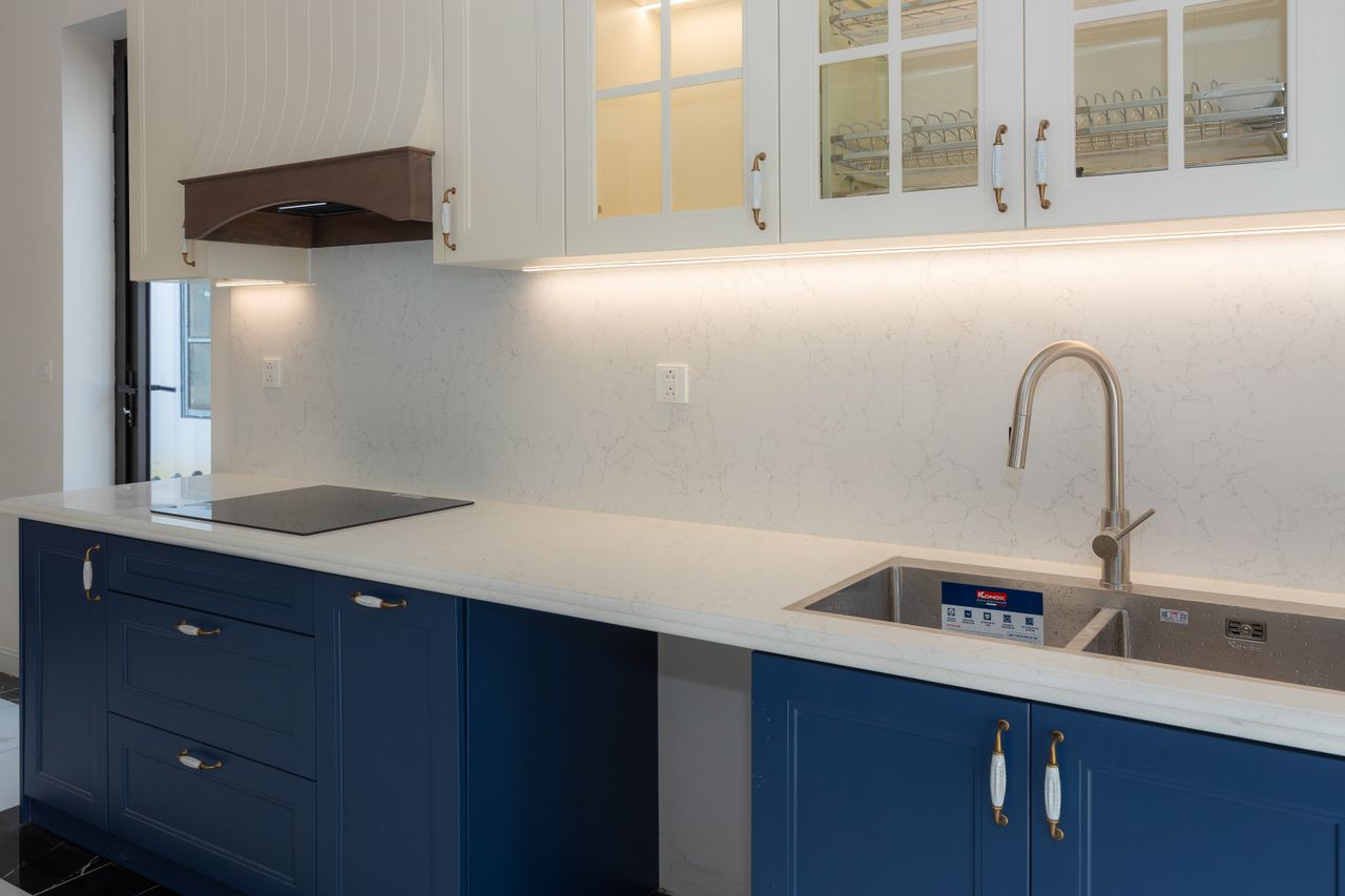 Services Sleek kitchen featuring blue cabinets, white countertops, and modern fixtures.
