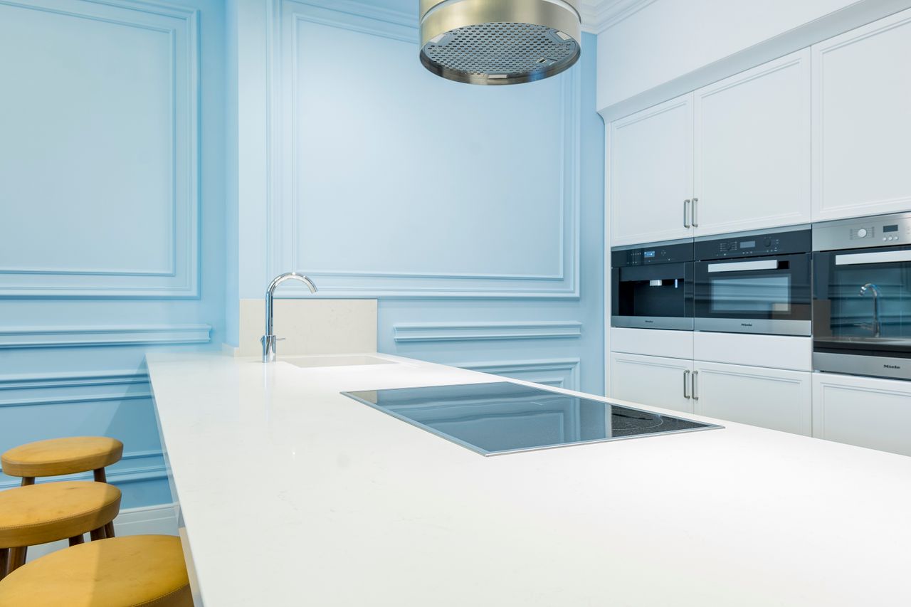 Crafting Captivating Headlines: Your awesome post title goes here Bright, modern kitchen with minimalist design featuring blue walls and sleek white countertops.