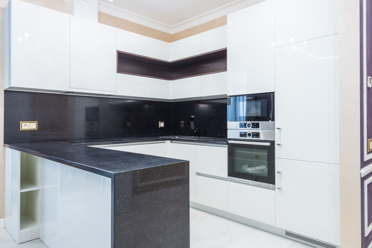 The Art of Drawing Readers In: Your attractive post title goes here Explore a sleek and modern kitchen with white cabinetry and black countertops.
